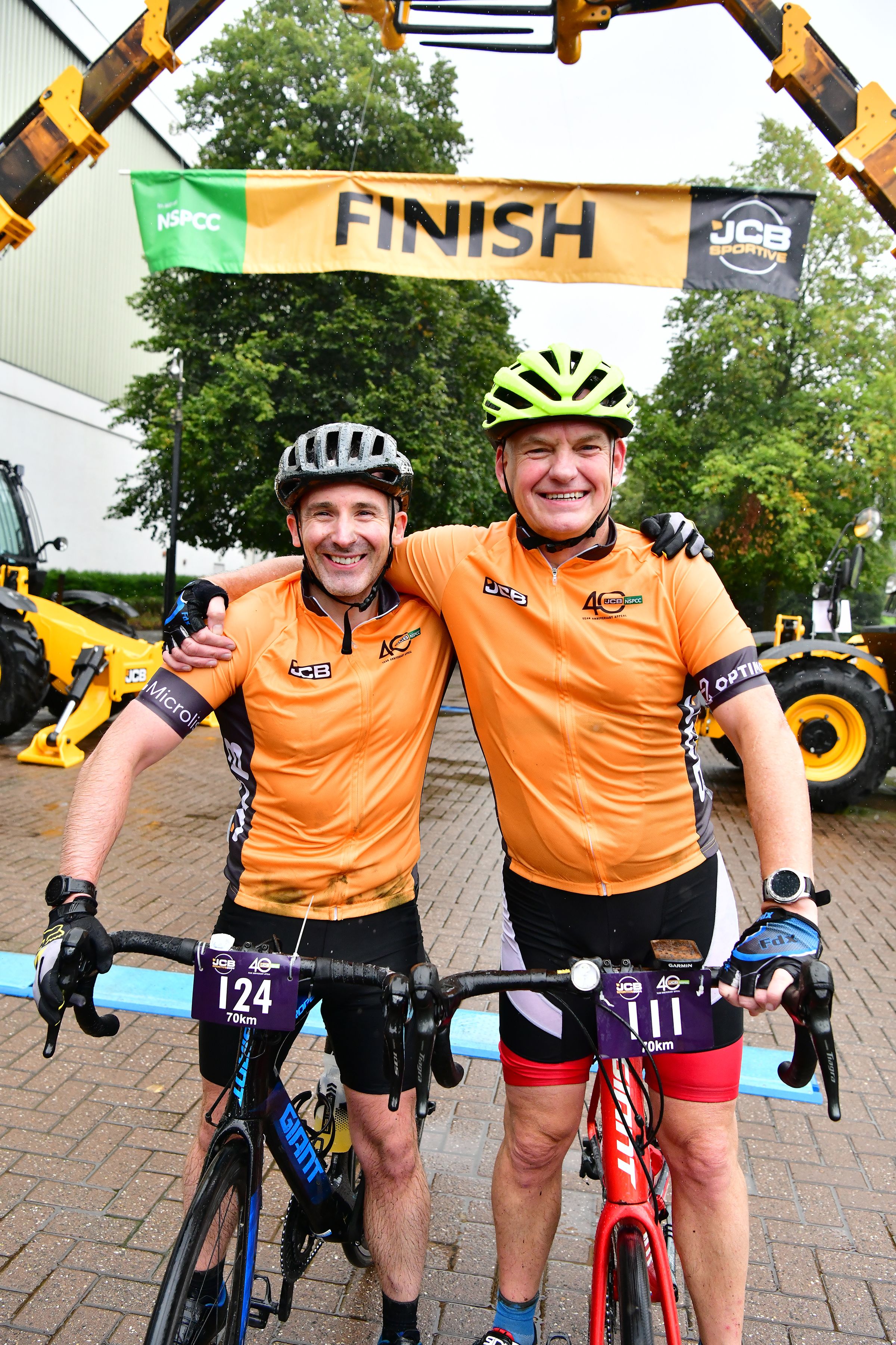 Two people in cycling gear that says 'JCB' and '40'
