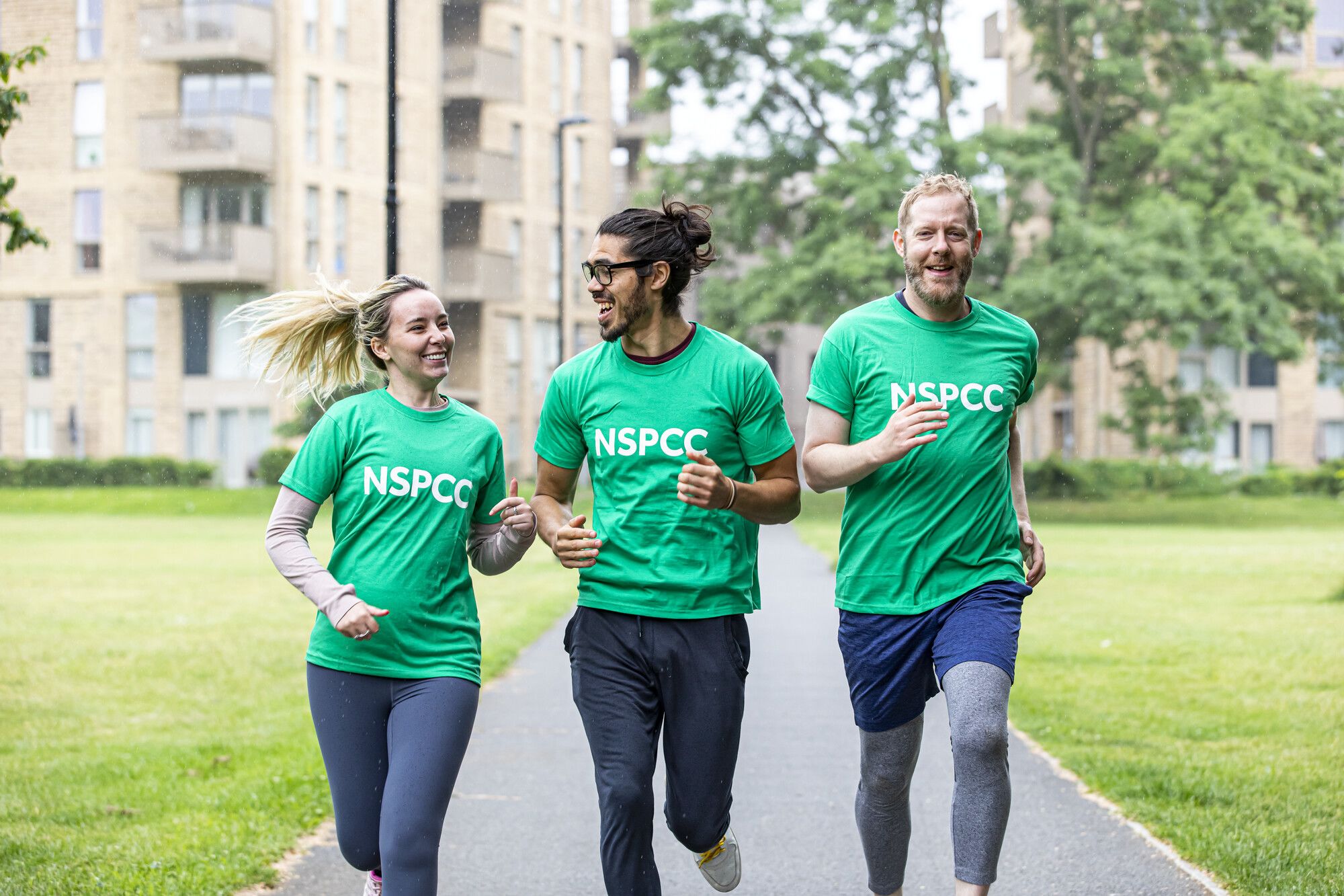 Three people running with NSPCC t-shirts on