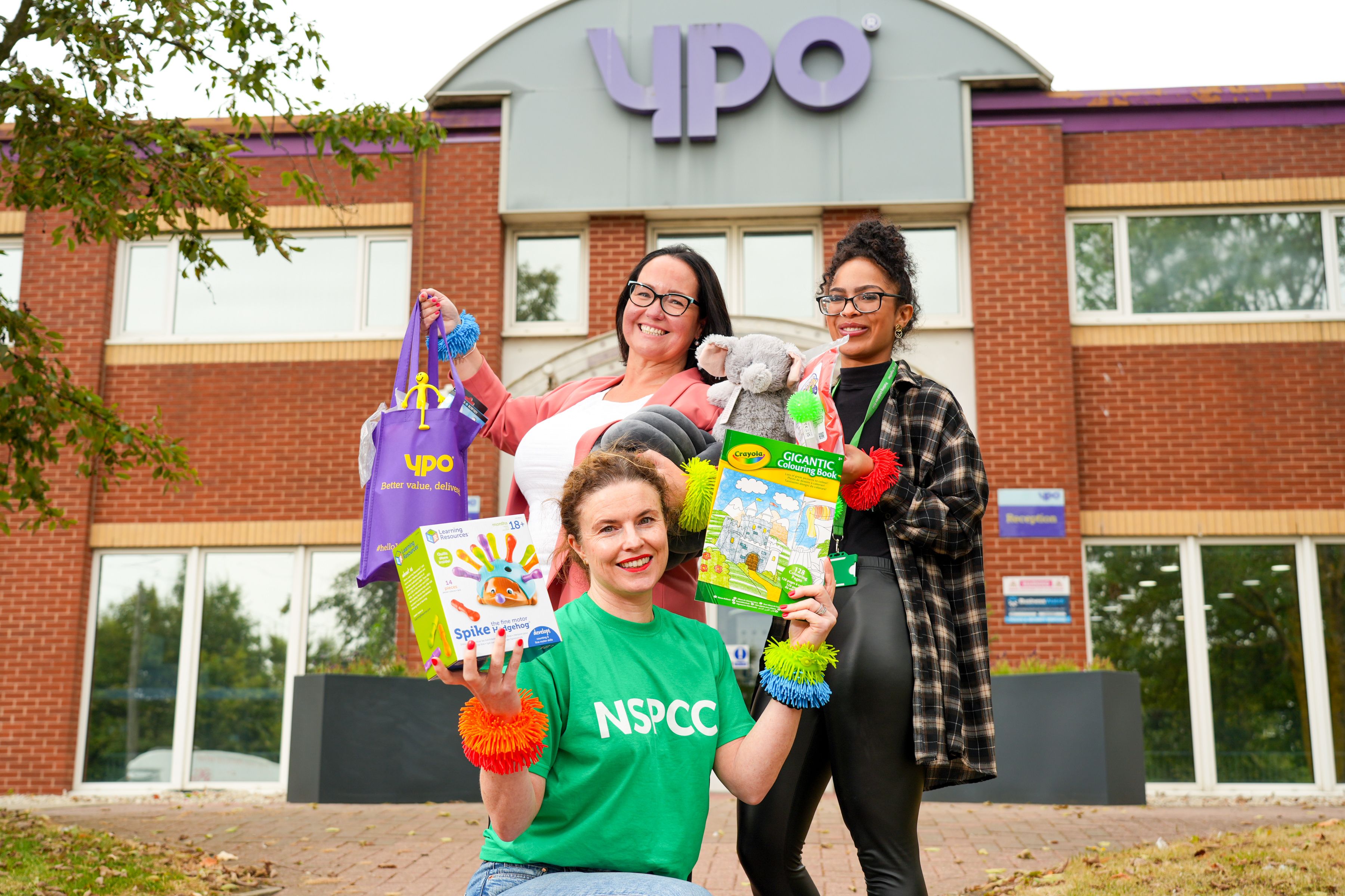 Three women holding YPO branded products