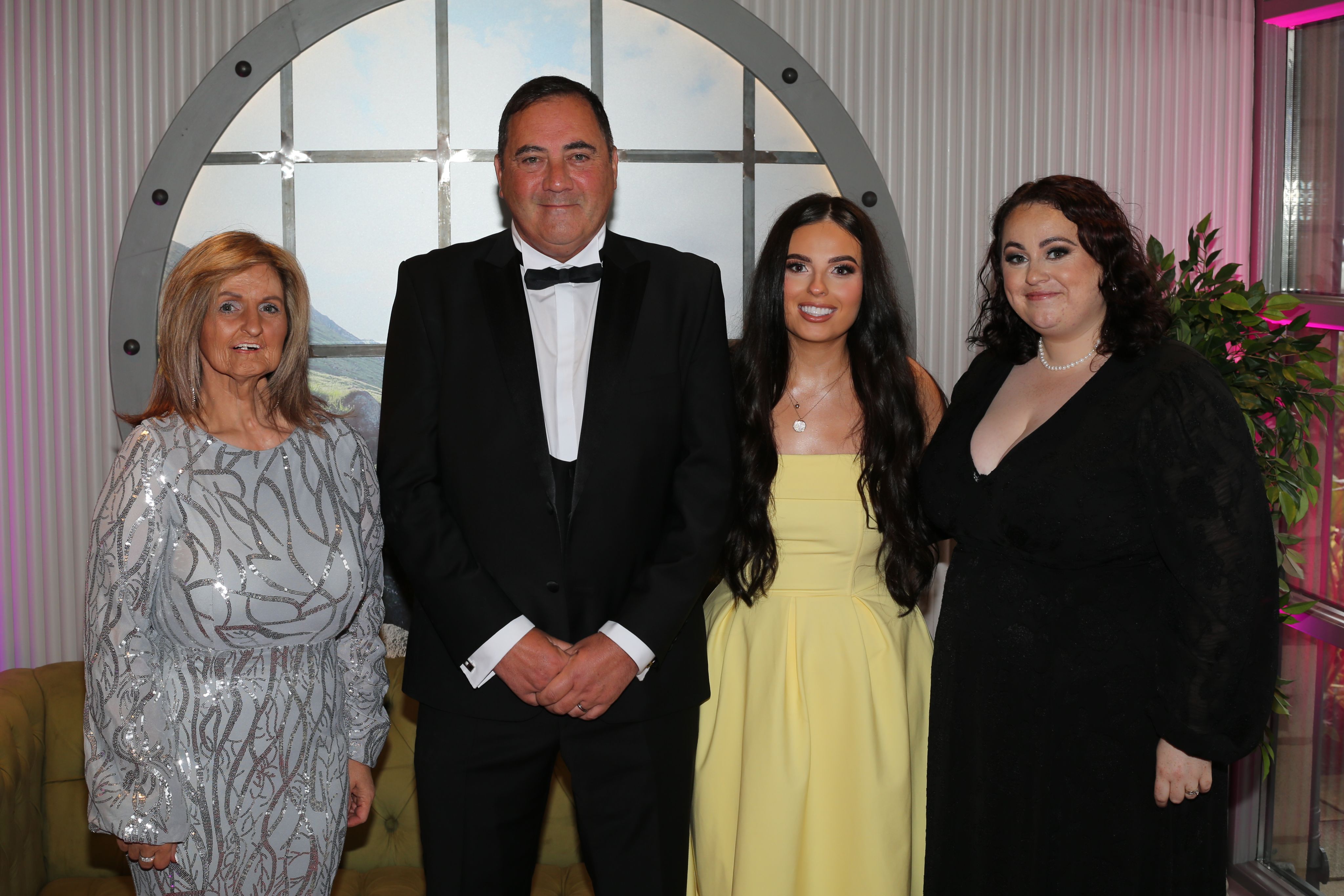 Four people dressed in smart dresses/a suit